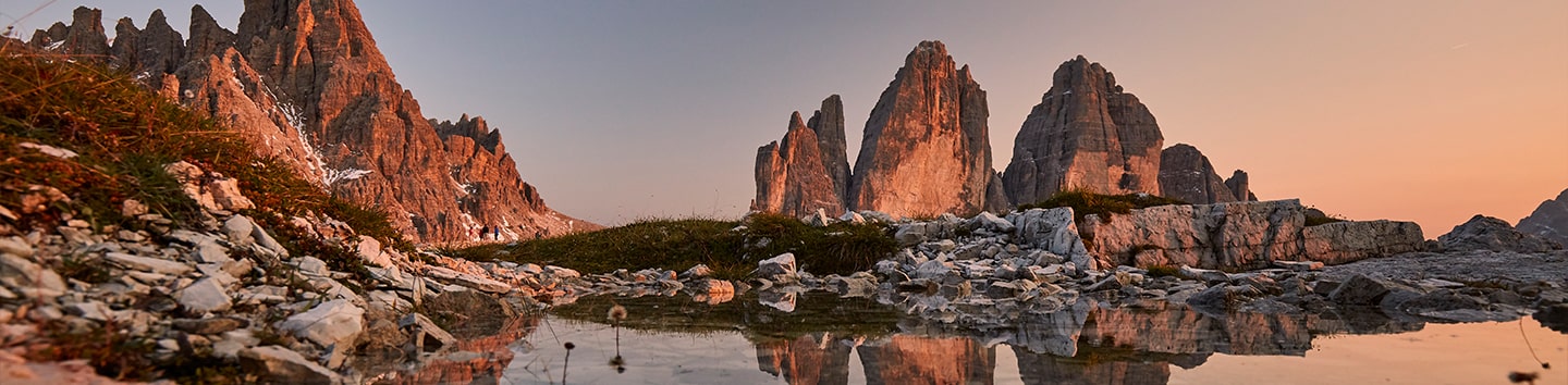 Berggruppe Drei Zinnen spiegeln sich in Wasser